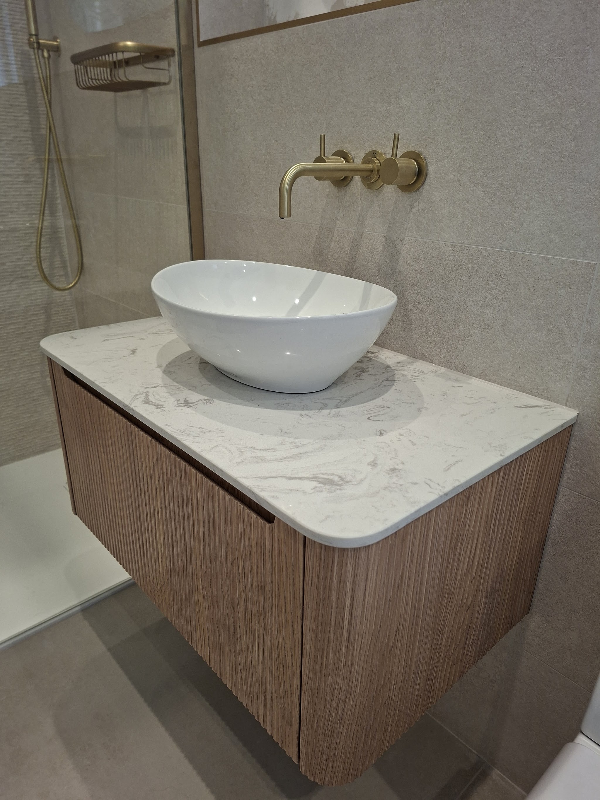 A closer look at the neutral wall tiles beside a timber vanity.